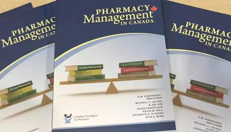 Picture of three pharmacy textbooks laid down on a table