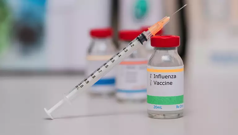 Blazing trails with flu shot claims | Picture of flu vaccine container with an injection needle on top of it - The Canadian Foundation For Pharmacy