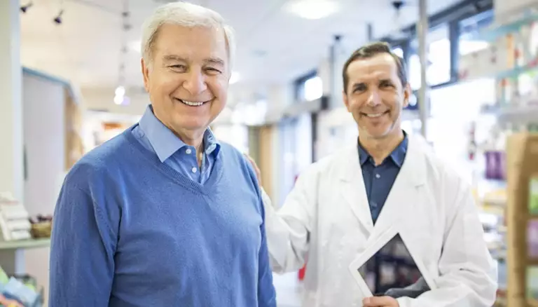 New CE on digital technology | Picture of pharmacists putting his hand on an older man's shoulder who is standing in front of him and looking at the camera - The Canadian Foundation For Pharmacy