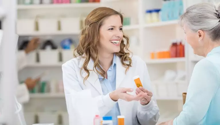 Value-based care can be better care for patients | Picture of female pharmacists showing a bottle of prescription to an older female patient - The Canadian Foundation For Pharmacy