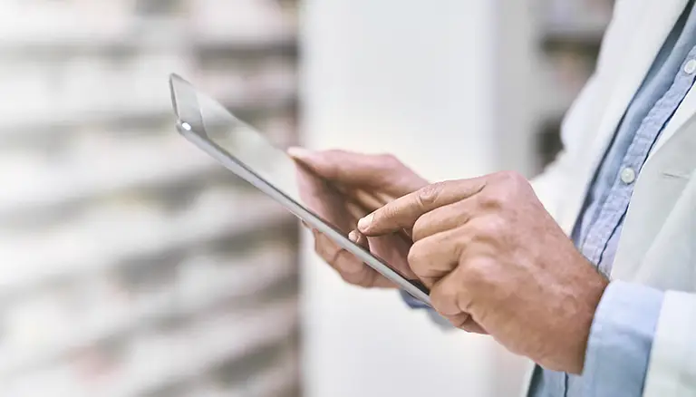 Our digital future | Image of pharmacist holding up a tablet, searching for imformation - The Canadian Foundation For Pharmacy